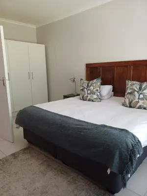 a bedroom with a large bed with a wooden headboard at Diamant Estate in Paarl