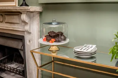 a plate of brownies on a table next to a fireplace at Corner House Residence in Franschhoek