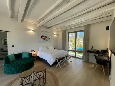 a bedroom with a bed and a couch in a room at Droom Guesthouse in Franschhoek