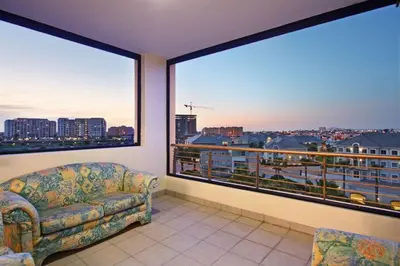 a living room with a couch and a large window at Knightsbridge 407 by Host Agents in Cape Town