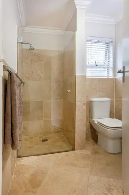 a bathroom with a toilet and a glass shower at Tuis en Tevrede - 2 Bedroom Flat in Hermanus