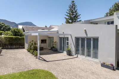 a white house with a patio in front of it at Tuis en Tevrede - 2 Bedroom Flat in Hermanus