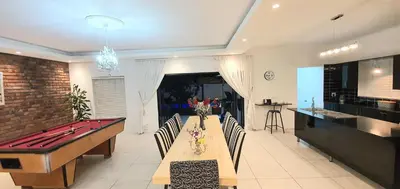 a dining room with a ping pong table and a kitchen at Villa Parisienne Modern Guest house in Cape Town