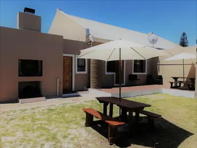 a picnic table with an umbrella and a bench at Proleefic House on Florence in Bellville
