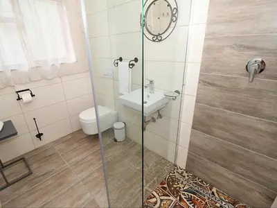 a bathroom with a shower with a toilet and a sink at Glennies Guesthouse in Somerset West