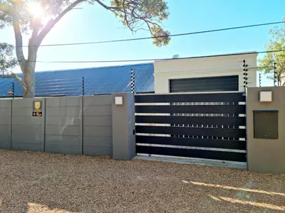 a fence in front of a house at The Anchor, Luxury living for 2 with sea view and Jacuzzi in Gordonʼs Bay