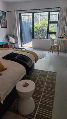 a bedroom with a bed and a large window at Yellow Door Hermanus in Hermanus