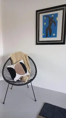 a chair with a blanket on it next to a wall at Yellow Door Hermanus in Hermanus