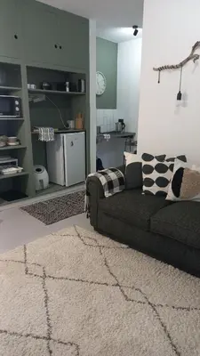a living room with a couch and a rug at Yellow Door Hermanus in Hermanus