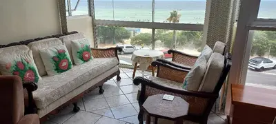 a living room with a couch and chairs and a view of the beach at St Tropez 301 in Strand