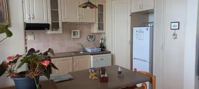 a kitchen with a table and a white refrigerator at St Tropez 301 in Strand
