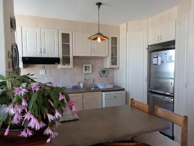 a kitchen with a table and a refrigerator at St Tropez 301 in Strand