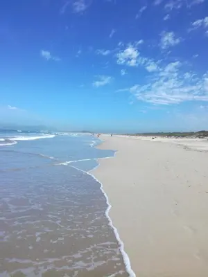 a beach with the tide coming in from the ocean at St Tropez 301 in Strand