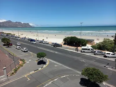 a city street with cars parked on the beach at St Tropez 301 in Strand
