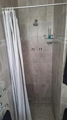 a shower with a shower curtain in a bathroom at Senelle accomodation in Hermanus