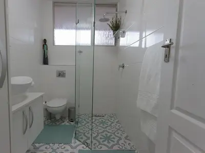 a bathroom with a glass shower and a toilet at Ocean-Song in Strand