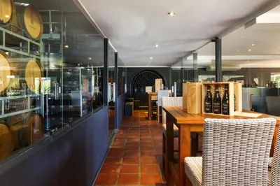 a restaurant with a table and chairs and a glass wall at Aaldering Luxury Lodges in Stellenbosch