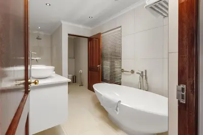 a white bathroom with a tub and a sink at Aaldering Luxury Lodges in Stellenbosch