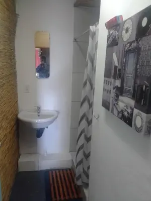 a bathroom with a sink and a mirror at Sunset beach backpackers in Bloubergstrand