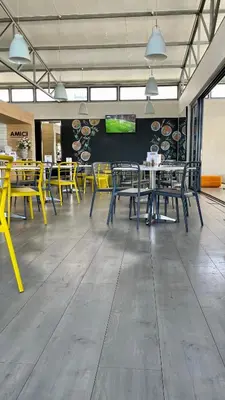 a cafeteria with tables and yellow chairs in a room at 417 The Sandown in Cape Town