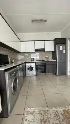 a kitchen with a washer and dryer in it at 417 The Sandown in Cape Town