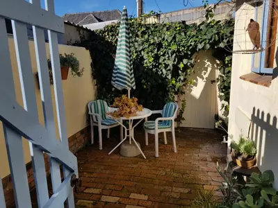 a patio with a table and two chairs and an umbrella at The Hermitage in Cape Town