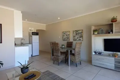 a kitchen and dining room with a table and a television at Complete self-catering apartment close to the beach in Cape Town