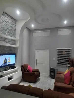 a living room with two chairs and a flat screen tv at Prince Olive in Cape Town