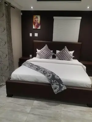 a bedroom with a large bed with white sheets at Prince Olive in Cape Town