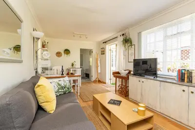 a living room with a gray couch and a table at Suburban bliss with Wifi and plunge pool in Cape Town