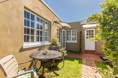 a patio with a table and chairs in front of a house at Suburban bliss with Wifi and plunge pool in Cape Town