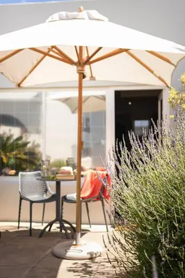 a table and chairs under an umbrella on a patio at Goozi Garden Cottage in Hermanus