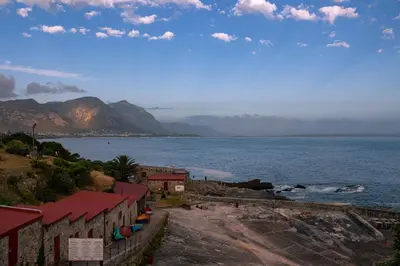 a view of a body of water with a mountain at Goozi Garden Cottage in Hermanus