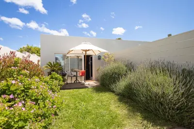 a garden with a gazebo and some plants at Goozi Garden Cottage in Hermanus