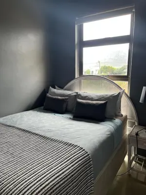 a bedroom with a large bed with a window at Edible Shores in Pringle Bay