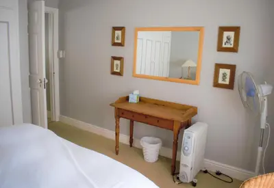 a bedroom with a table and a mirror and a bed at Mafunyani Cottage in Franschhoek