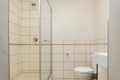 a bathroom with a shower with a toilet and a sink at The Manhattan Apartments in Cape Town