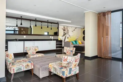 a living room with a table and chairs at The Manhattan Apartments in Cape Town