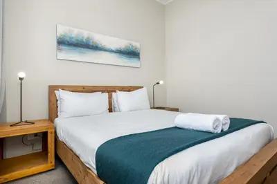 a bedroom with a bed with a green and white blanket at The Axis Luxury Apartments in Cape Town
