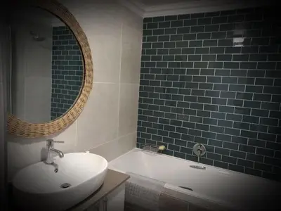 a bathroom with a sink and a tub and a mirror at Bay-Side Apartment, Gordon's Bay in Gordonʼs Bay