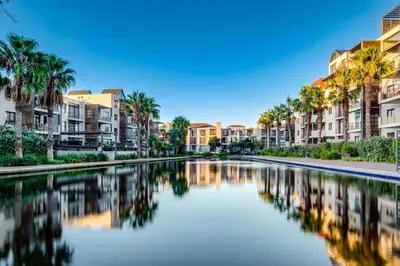 a canal in a city with palm trees and buildings at Belina - Quayside Canal Front in Cape Town