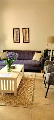 a living room with a purple couch and a coffee table at De Molen Guest House in Somerset West