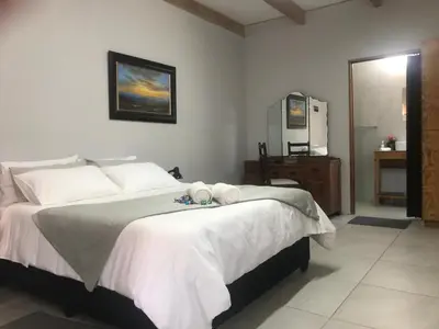 a bedroom with a large bed and a television at Kunsvilla in Durbanville