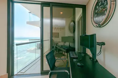 an office with a desk with a computer and a window at Luxury Ocean View 1203 in Cape Town