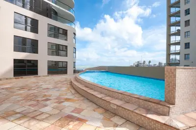 a swimming pool next to a building at Luxury Ocean View 1203 in Cape Town