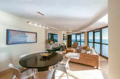 a dining room and living room with a table and chairs at Luxury Ocean View 1203 in Cape Town