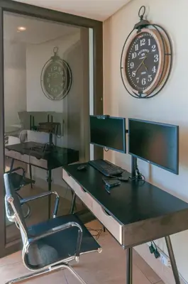 an office with two desks and a clock on the wall at Luxury Ocean View 1203 in Cape Town