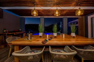 a dining room with a wooden table and chairs at House w Pool, Fireplace, Braai in Cape Town