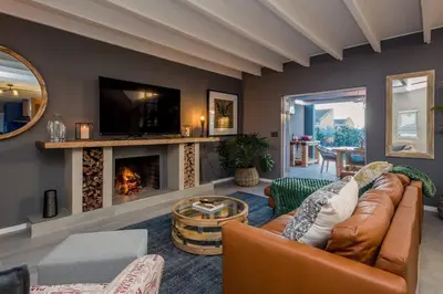 a living room with a couch and a fireplace at House w Pool, Fireplace, Braai in Cape Town