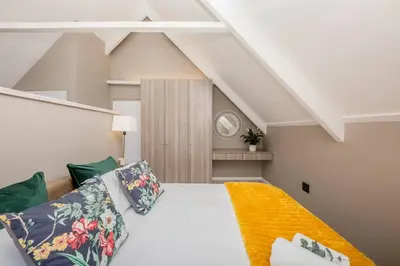 a bedroom with a large white bed and green pillows at House w Pool, Fireplace, Braai in Cape Town
